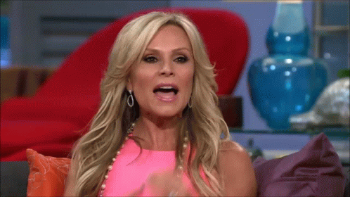 A Woman In A Pink Top Is Sitting On A Couch GIF