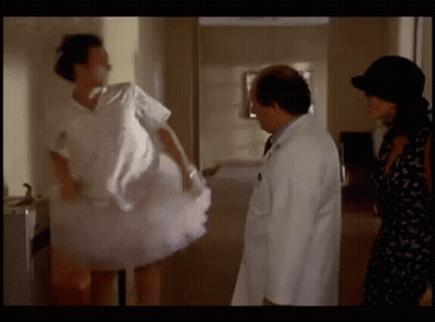 A Woman In A Pink Tutu Is Standing Next To A Doctor And A Woman In A Black Dress . GIF
