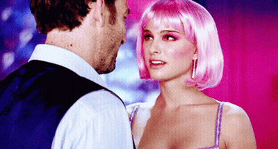 A Woman In A Pink Wig Looks At A Man In A Blue Vest GIF
