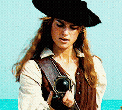 A Woman In A Pirate Costume Is Holding A Cannon GIF