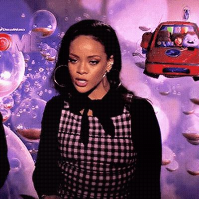 A Woman In A Plaid Dress Stands In Front Of A Sign That Says Dreamworks GIF