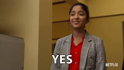 A Woman In A Plaid Jacket Is Smiling And Says Yes GIF