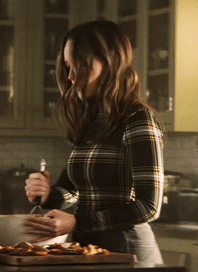 A Woman In A Plaid Shirt Is Cooking In A Kitchen GIF