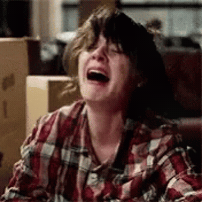 A Woman In A Plaid Shirt Is Laughing And Crying . GIF