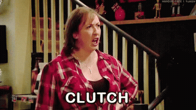 A Woman In A Plaid Shirt Is Screaming And Saying Clutch While Standing On A Set Of Stairs . GIF