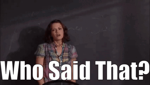 A Woman In A Plaid Shirt Is Standing In Front Of A Blackboard With The Words Who Said That . GIF