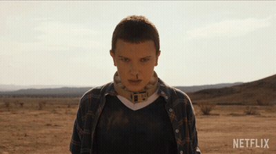 A Woman In A Plaid Shirt Stands In The Desert With Netflix Written On The Bottom GIF