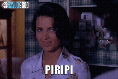 A Woman In A Plaid Shirt With The Word Piripi On Her Chest GIF