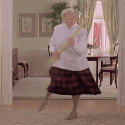 A Woman In A Plaid Skirt Is Holding A Broom In Her Hand GIF