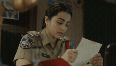 A Woman In A Police Uniform Is Holding A Piece Of Paper In Her Hand . GIF