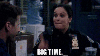 A Woman In A Police Uniform Is Sitting At A Table With A Man And Talking To Him . GIF