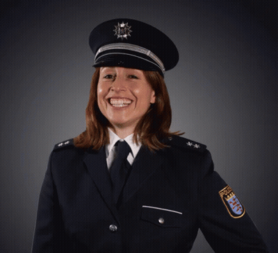 A Woman In A Police Uniform Is Smiling And Wearing A Badge That Says Police GIF