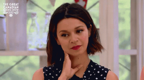 A Woman In A Polka Dot Dress Is Making A Funny Face With Her Hand On Her Chin . GIF