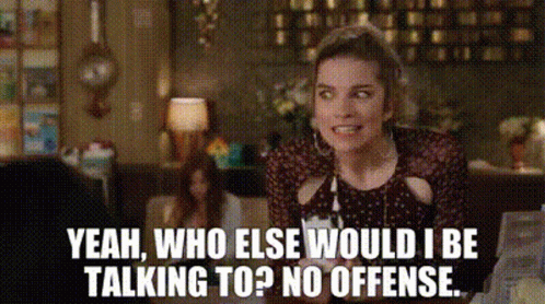A Woman In A Polka Dot Dress Is Talking To Someone In A Restaurant . GIF
