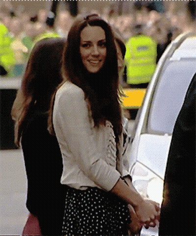A Woman In A Polka Dot Skirt Smiles While Standing Next To A Car GIF