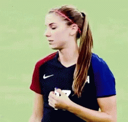 A Woman In A Ponytail Is Wearing A Nike Shirt And A Headband . GIF