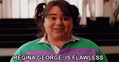 A Woman In A Purple And Green Striped Shirt Is Smiling And Says `` Regina George Is Flawless '' . GIF