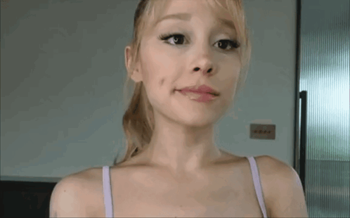 A Woman In A Purple Bra Is Making A Funny Face With Her Mouth Open . GIF