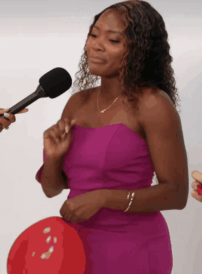 A Woman In A Purple Dress Is Being Interviewed GIF