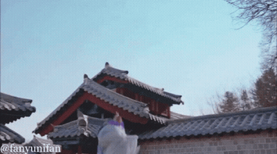 A Woman In A Purple Dress Is Dancing In Front Of A Brick Building With The Hashtag Fanyumifan GIF