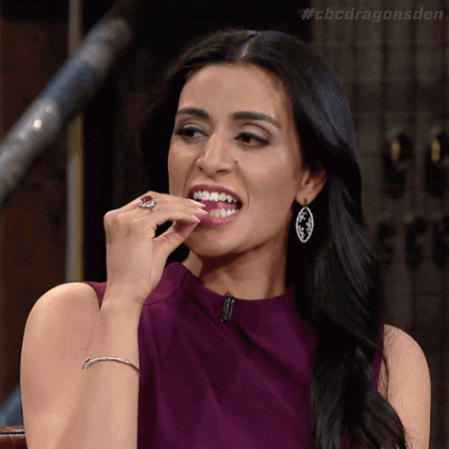 A Woman In A Purple Dress Is Eating Something With The Hashtag #Cbcdragonsden GIF