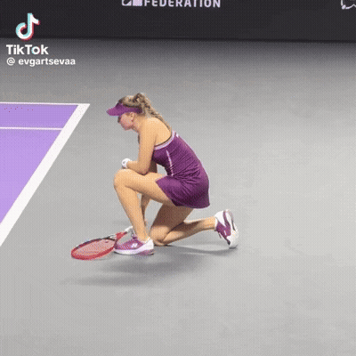 A Woman In A Purple Dress Is Kneeling Down On A Tennis Court With A Tiktok Watermark GIF