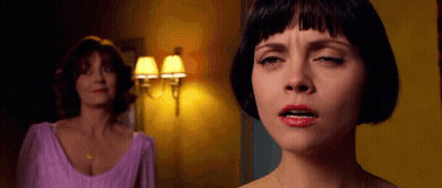 A Woman In A Purple Dress Is Making A Face While Another Woman Looks On GIF