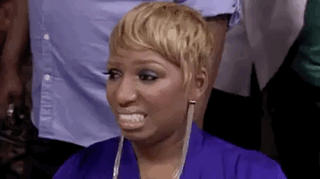 A Woman In A Purple Dress Is Making A Funny Face While Sitting In Front Of A Crowd . GIF