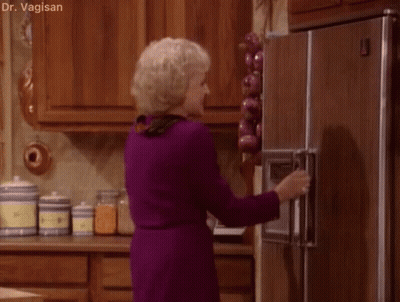 A Woman In A Purple Dress Is Opening The Door Of A Refrigerator . GIF