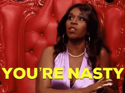 A Woman In A Purple Dress Is Sitting In A Red Chair With The Words You 'Re Nasty In Yellow Letters Behind Her GIF