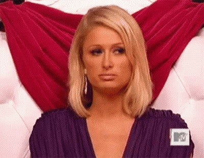 A Woman In A Purple Dress Is Sitting On A Couch . GIF