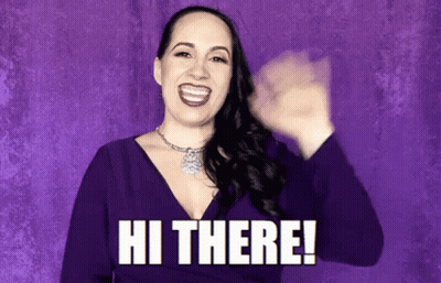 A Woman In A Purple Dress Is Smiling And Waving Her Hand With The Words Hi There . GIF