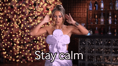 A Woman In A Purple Dress Says " Stay Calm " In Front Of A Bar GIF
