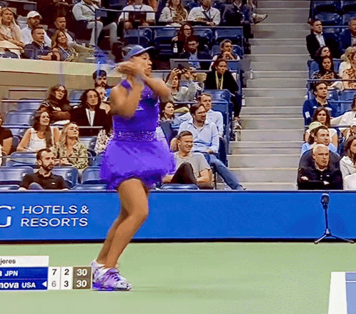 A Woman In A Purple Dress Stands On A Tennis Court In Front Of A Hotel And Resorts Banner GIF
