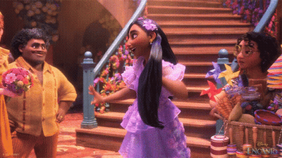 A Woman In A Purple Dress With A Flower In Her Hair Stands In Front Of Stairs GIF