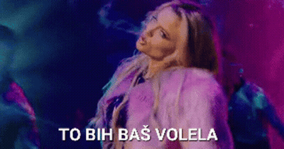 A Woman In A Purple Fur Coat Is Dancing In Front Of A Purple And Blue Background . GIF