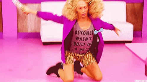 A Woman In A Purple Jacket And Leopard Print Shorts Is Kneeling On The Floor Holding A Broom . GIF