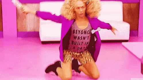 A Woman In A Purple Jacket And Leopard Print Shorts Is Kneeling On The Floor In A Room . GIF