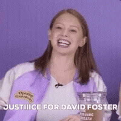 A Woman In A Purple Jacket Is Laughing And Holding A Glass . GIF