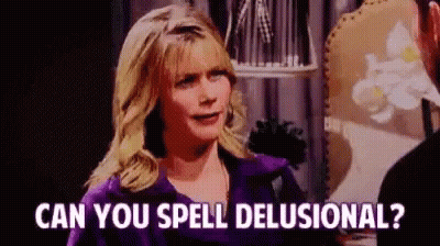 A Woman In A Purple Jacket Is Talking To A Man In A Room And Asking Him If He Can Spell Delusional . GIF