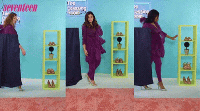 A Woman In A Purple Outfit Is Standing In Front Of A Sign That Says Seventeen GIF