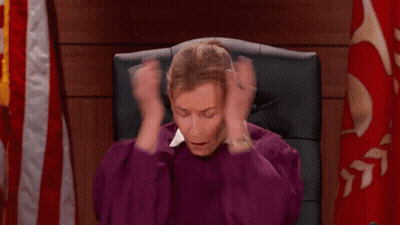 A Woman In A Purple Robe Is Sitting In A Chair Holding Her Hands To Her Head . GIF