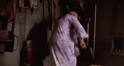 A Woman In A Purple Robe Is Standing In A Room With A Shovel GIF