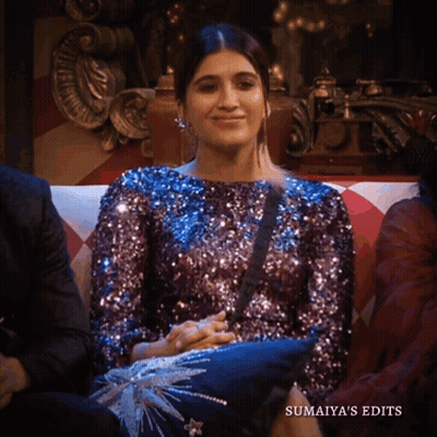 A Woman In A Purple Sequined Top Sits On A Couch With The Words Sumaiya 'S Edits Below Her GIF