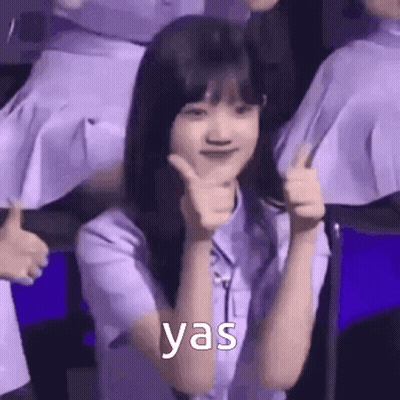 A Woman In A Purple Shirt Is Giving A Thumbs Up Sign . GIF