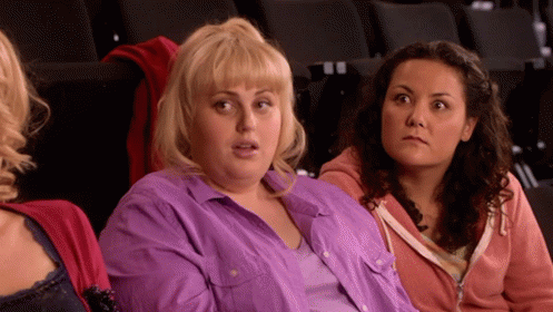 A Woman In A Purple Shirt Is Sitting Next To Another Woman . GIF