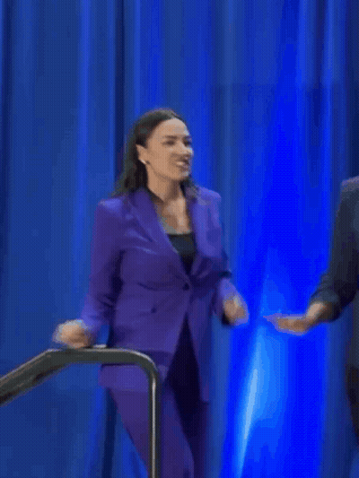 A Woman In A Purple Suit Is Smiling And Dancing GIF