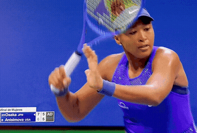 A Woman In A Purple Tank Top Holds A Tennis Racket GIF