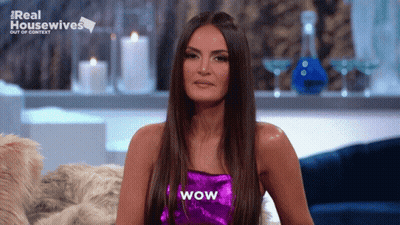 A Woman In A Purple Top With Wow Written On It GIF