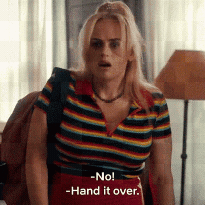 A Woman In A Rainbow Striped Shirt Is Standing In A Room . GIF